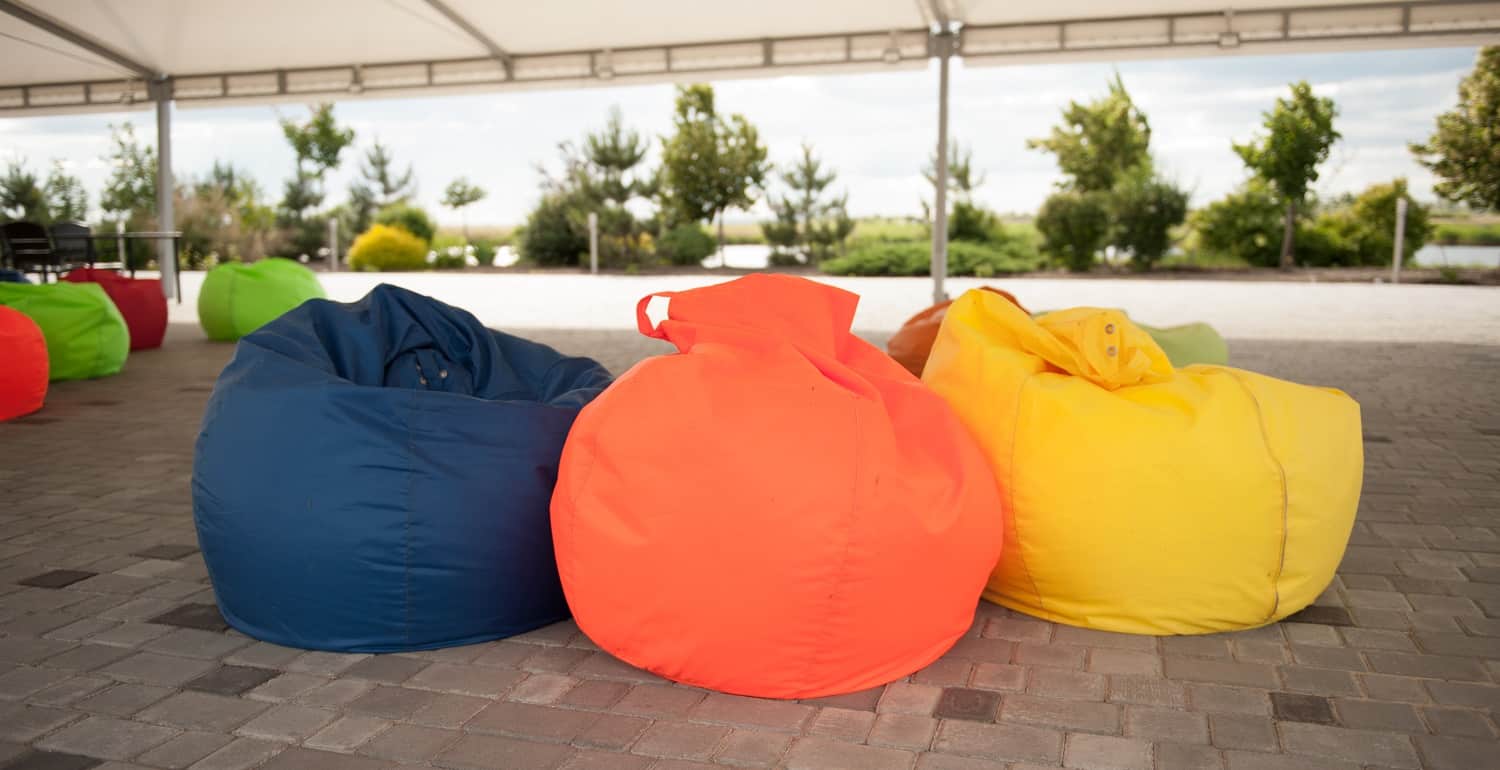 many colorful soft beanbag seats. under a canopy for relaxing