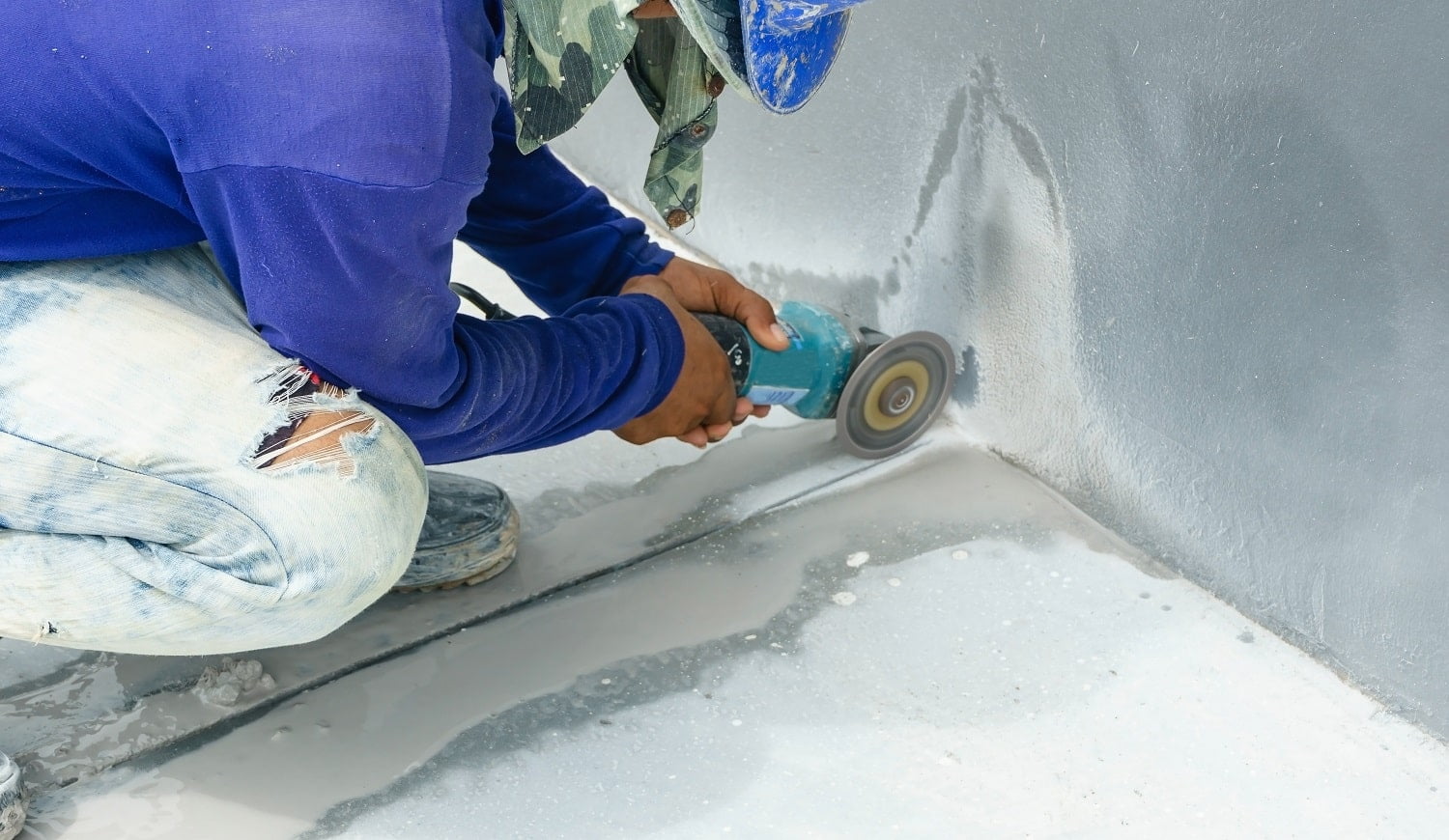 Worker grind hard floor. Worker with high shear grinder cut and mill cement or asphalt or concrete to separate surface of floor away. Danger job.