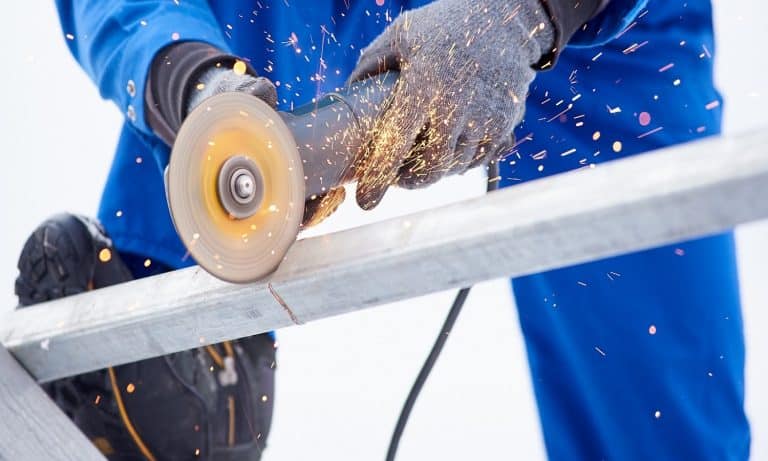 Cropped shot of a technician worker cutting steel on sonstruction site welding constructionist work profession occupation job craft metal metalworking industrial equipment tools.