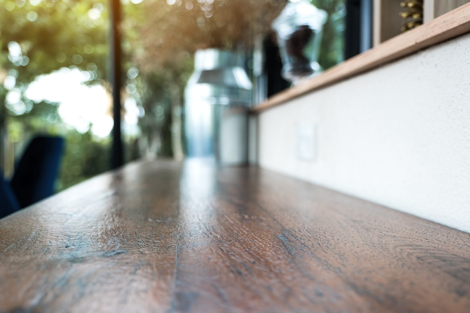 Closeup image of a wooden bar with flowerpots with blur green na