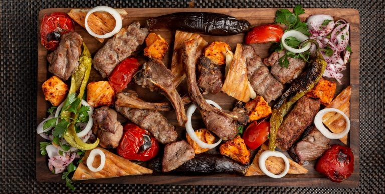 assorted meat kebab with onions herbs and grilled vegetables