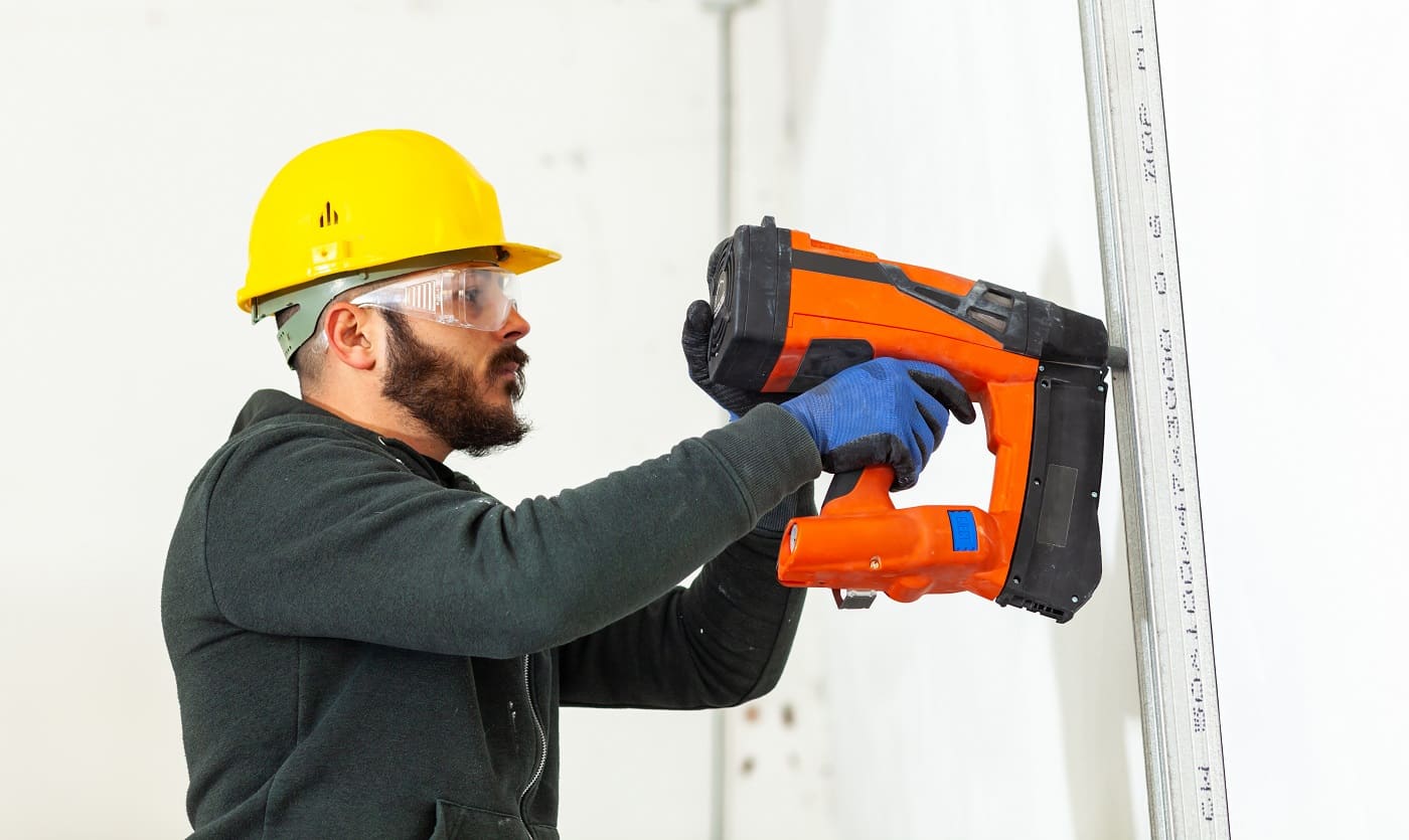 Worker at work in the construction of a plasterboard wall.