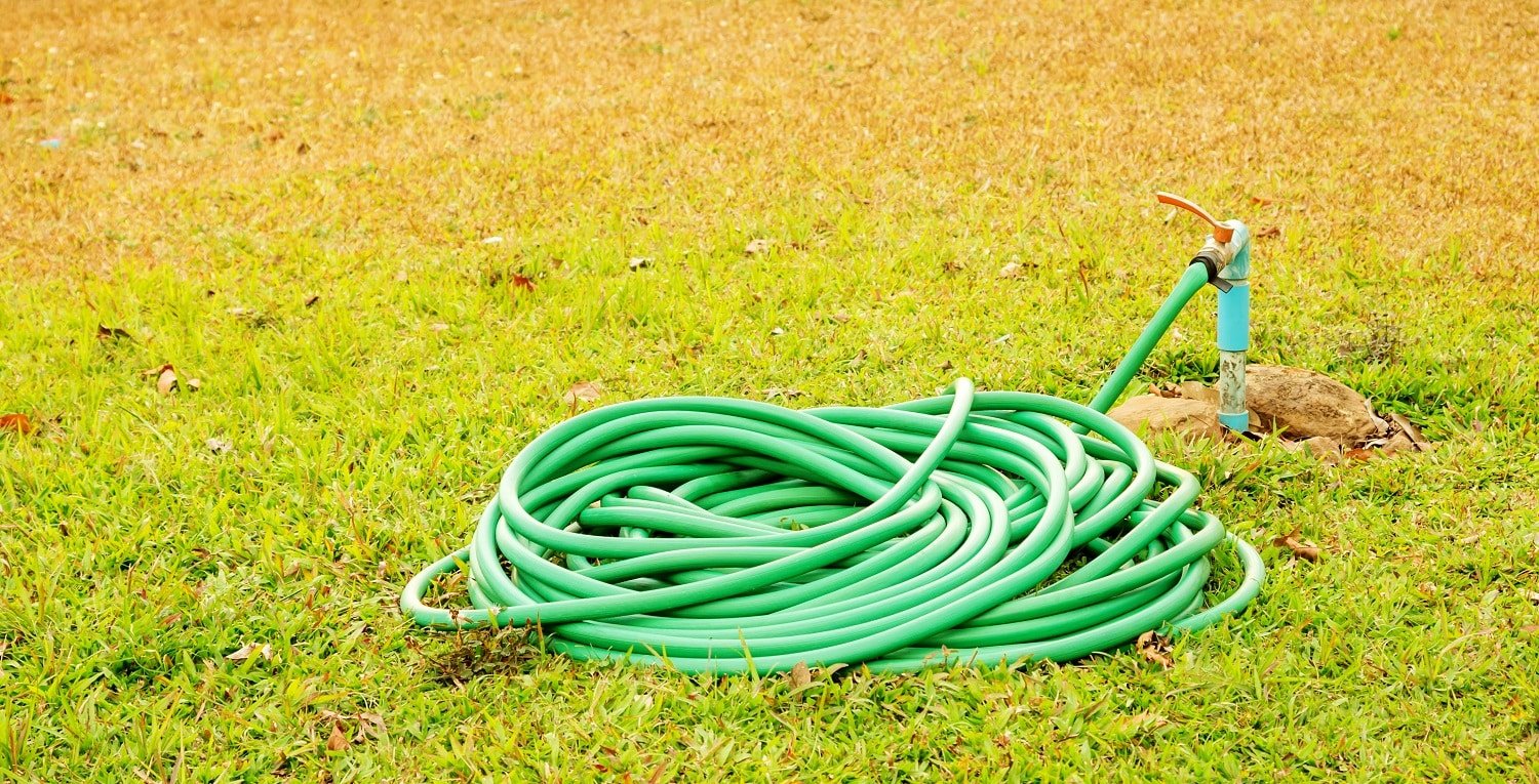 Tap and rubber tube on a grass.