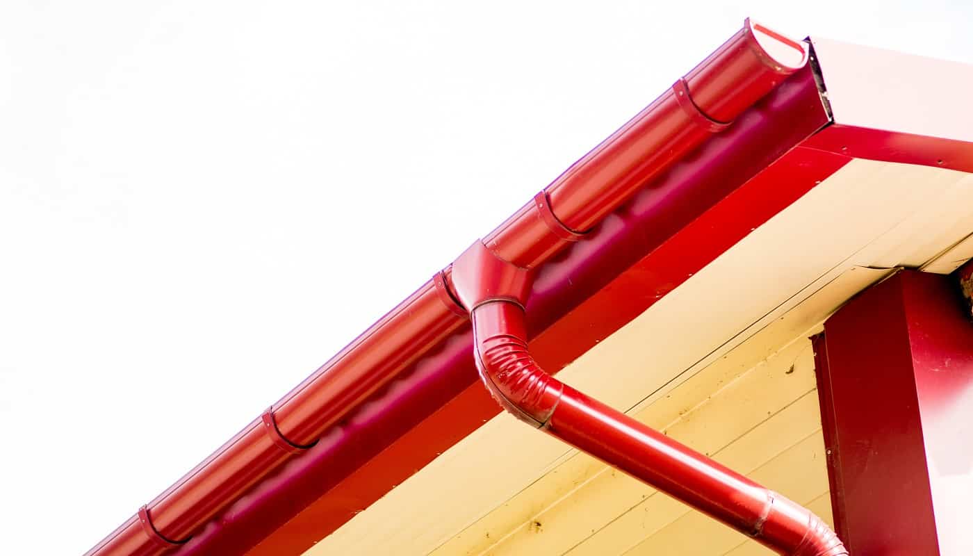 Red gutter on the roof top of house.