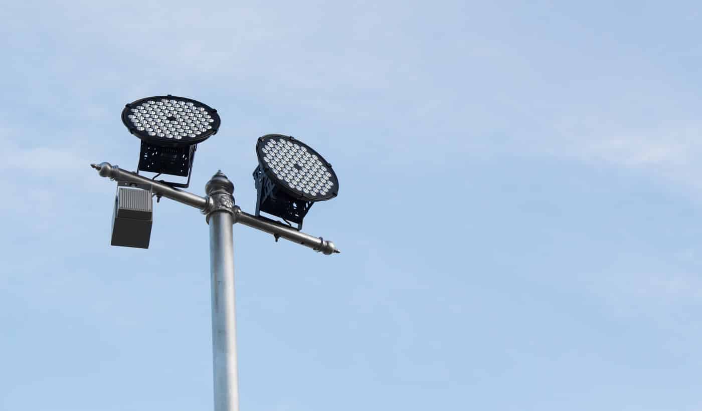 Silver lamp post with a light LED bulb on the left side and background sky. Technology of energy saving lamp based on the pole.