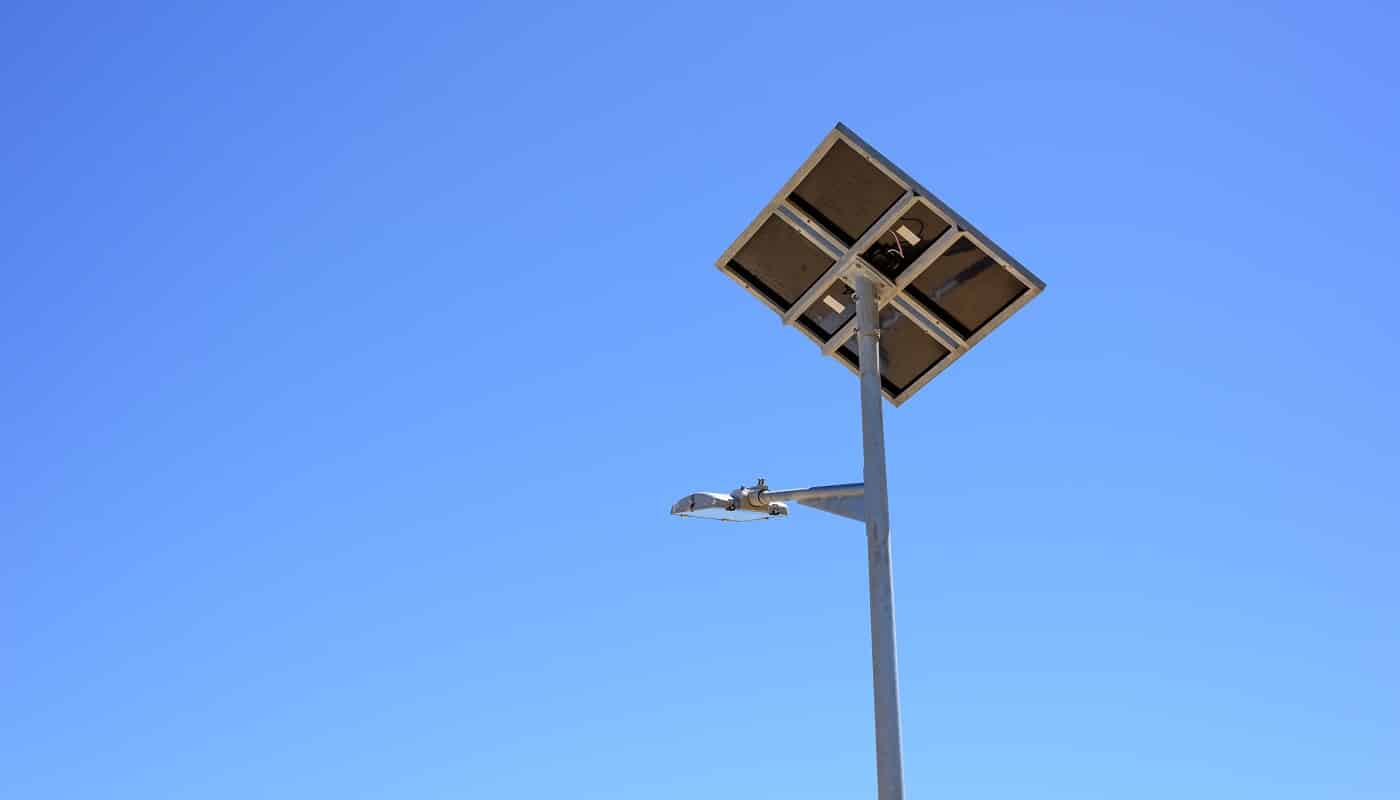 Street light with solar panel on blue sky background. Green energy.