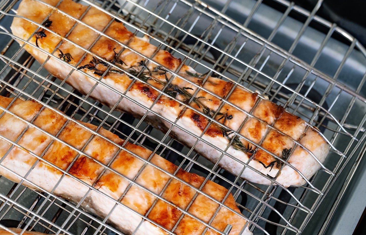 Salmon fillet cooking on grid. Red Fish roasting on electric grill. Food background.