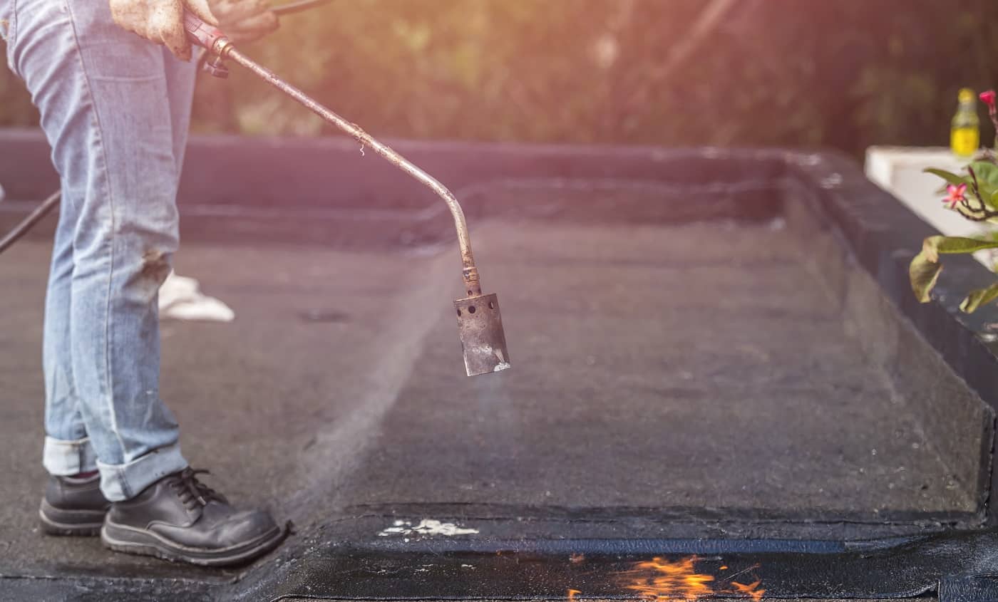 Asia worker installing tar foil on the rooftop