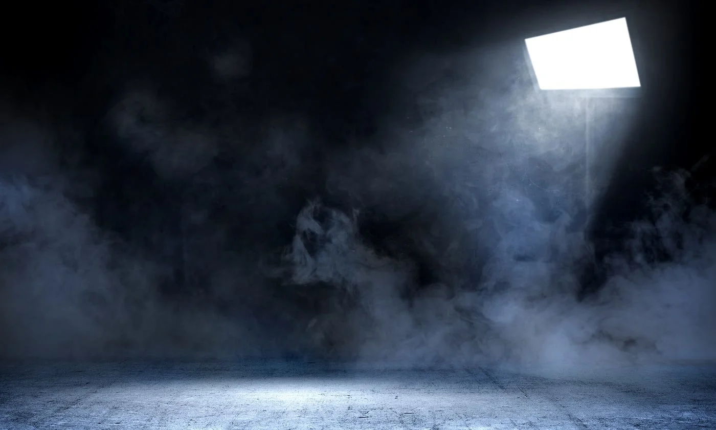 Room with concrete floor and smoke with light from spotlights against dark wall background