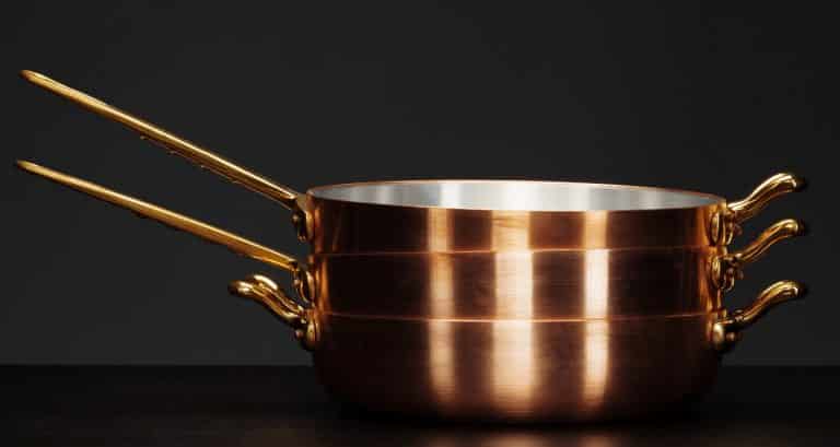 Set of copper cookware over dark background