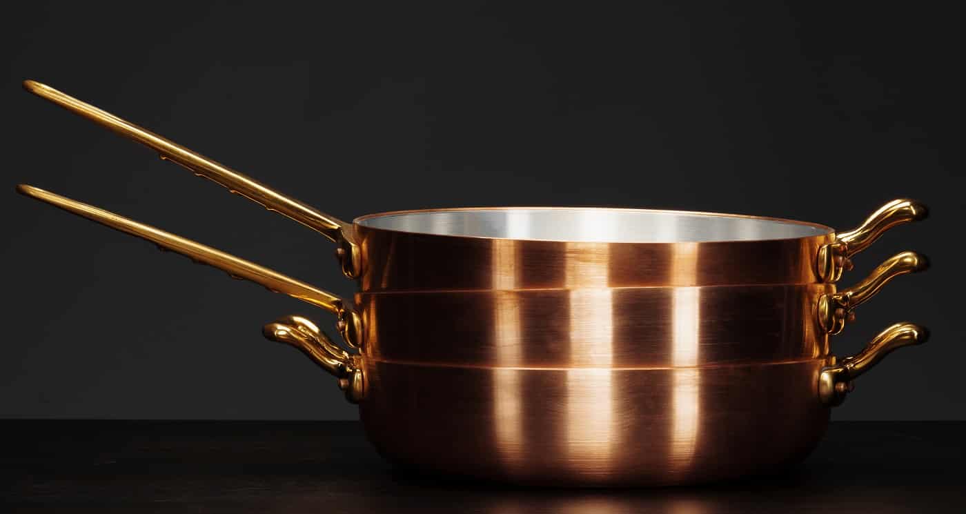 Set of copper cookware over dark background