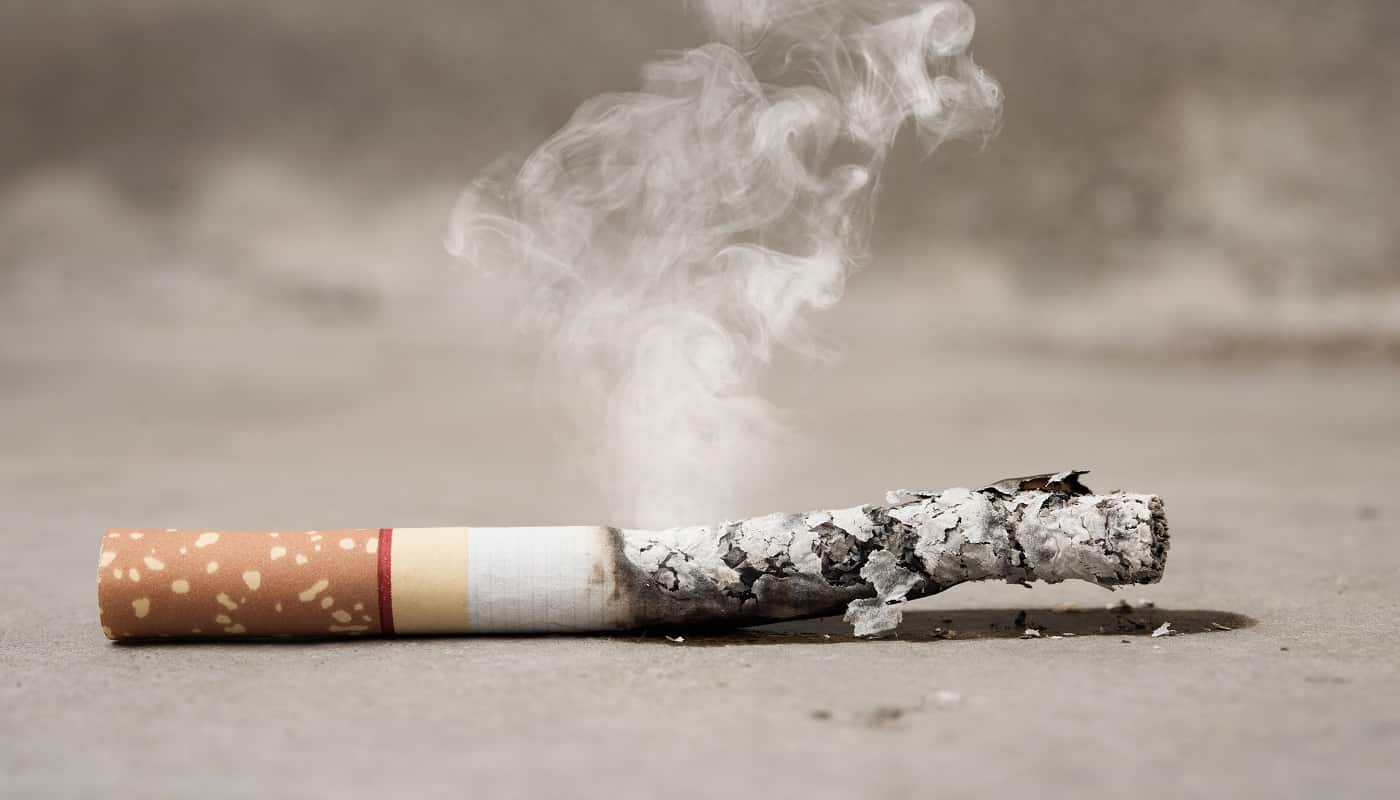 Close up cigarette burning on concrete floor , stop quitting tobacco concept
