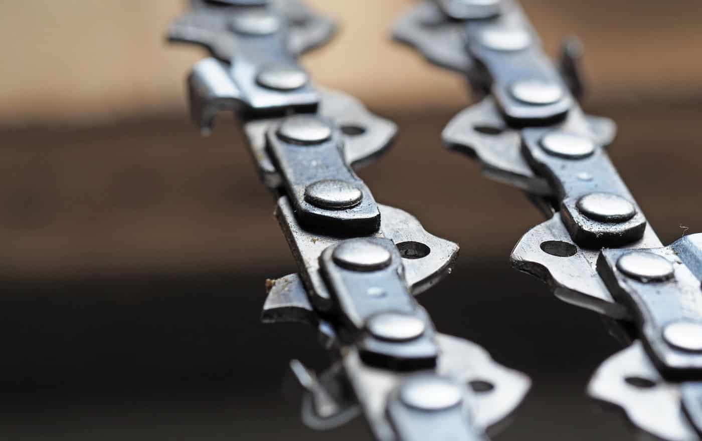 metal chainsaw chain with sharp teeth close-up with blurred background