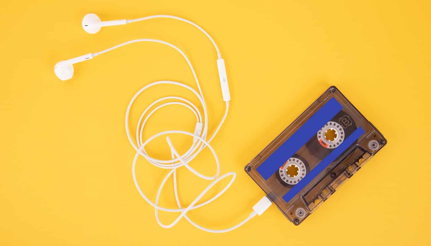 Tape cassette and white headphones. Composition in the form of a player on a yellow background.