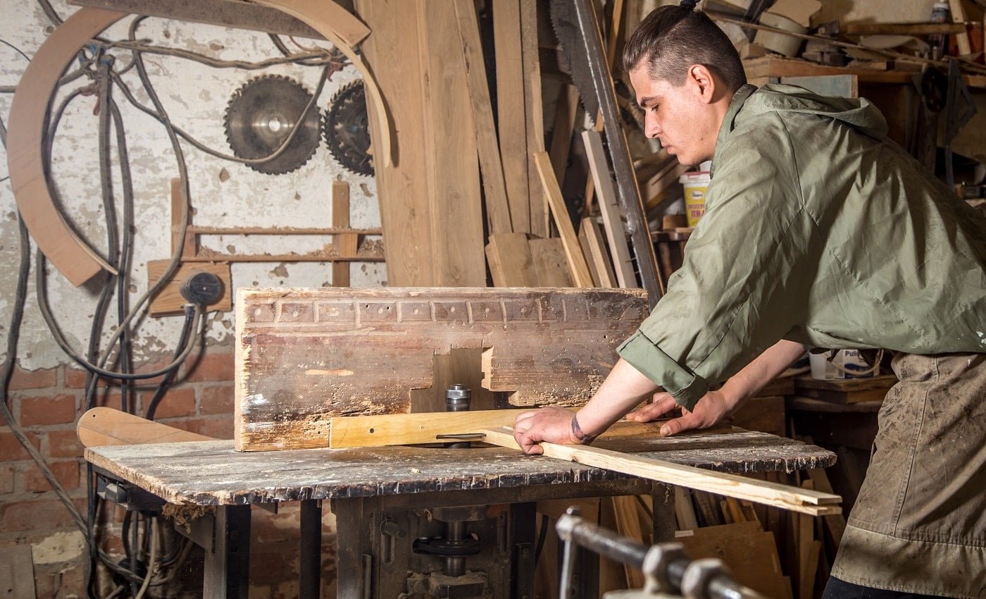 a man works on the machine with the wooden product manufacturing