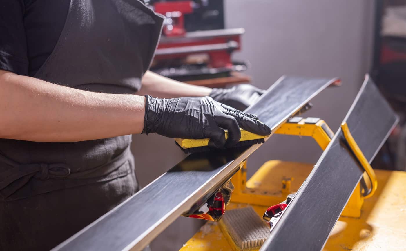 Work and repair concept - a man's hands repairing the ski by rubbing a paraffin. Food Safe Wood Finish