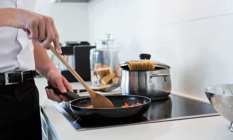 Mid-section of a man preparing food in kitchen at home