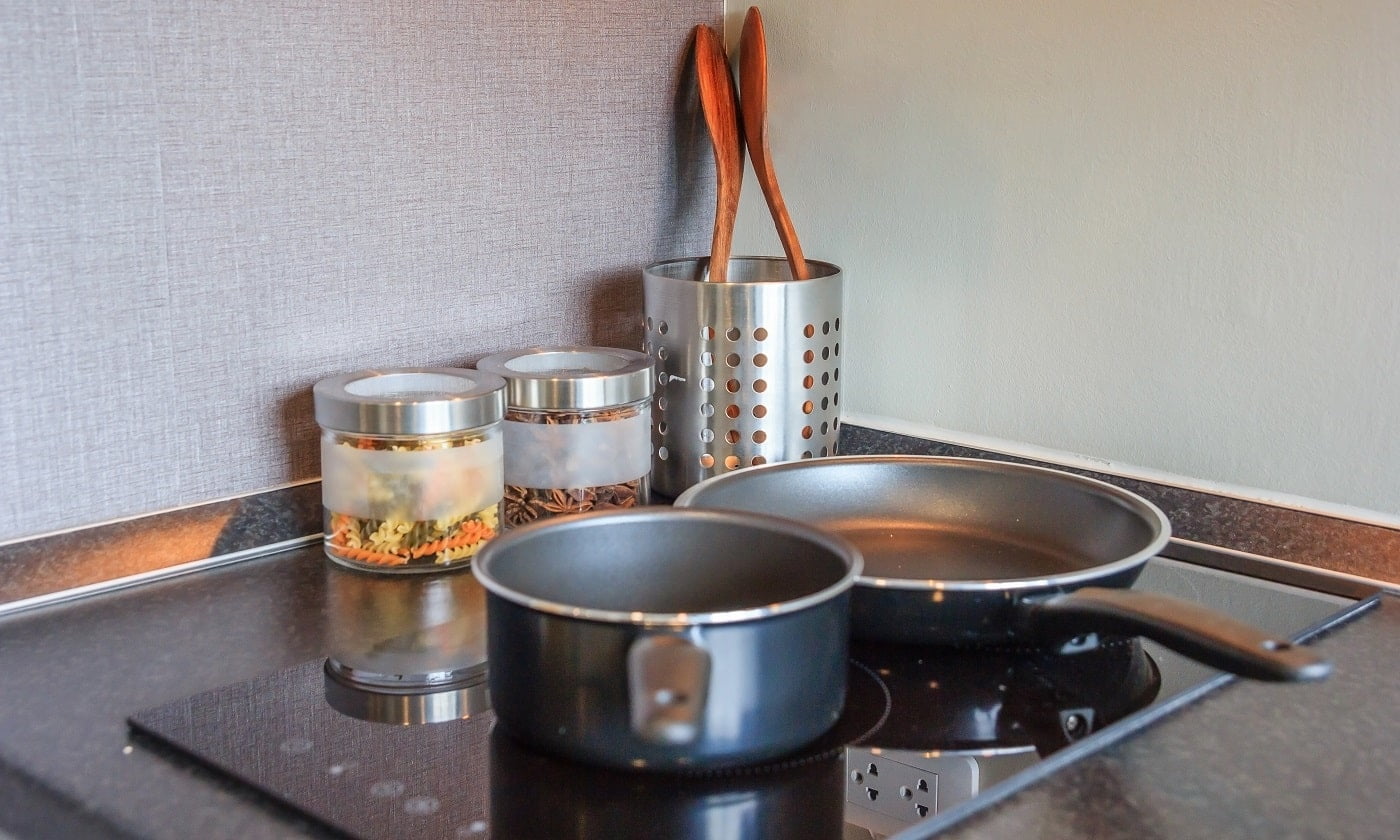 Black pan on Induction stove top panel in modern kitchen for cooking, closeup. Waring Pro ICT400