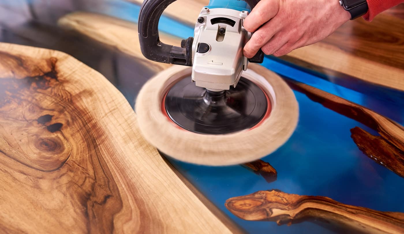 man polishing epoxy table close up.