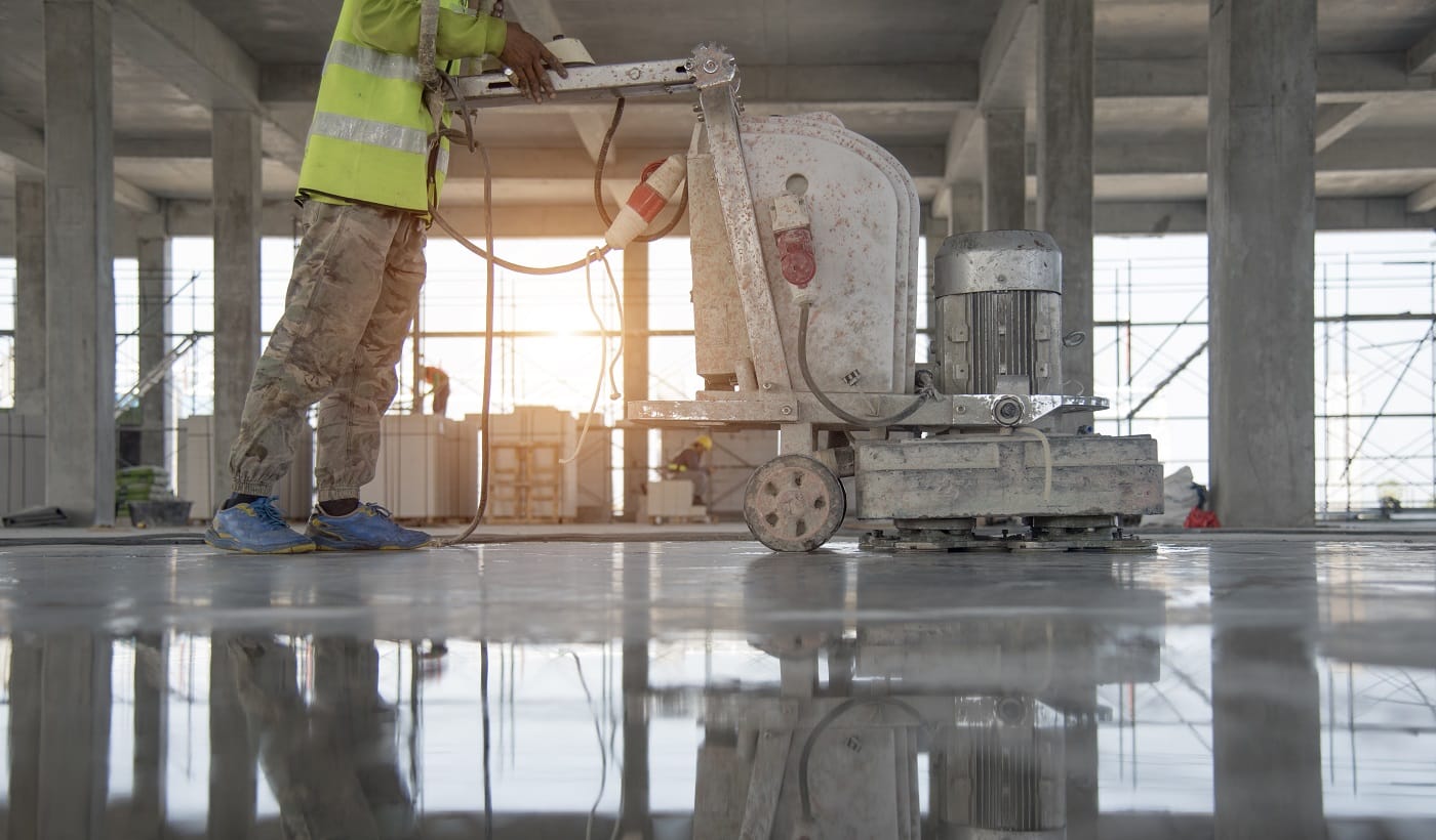 Construction worker produces the grout and finish wet concrete with a special tool. Float blades. For smoothing and polishing concrete, concrete floors
