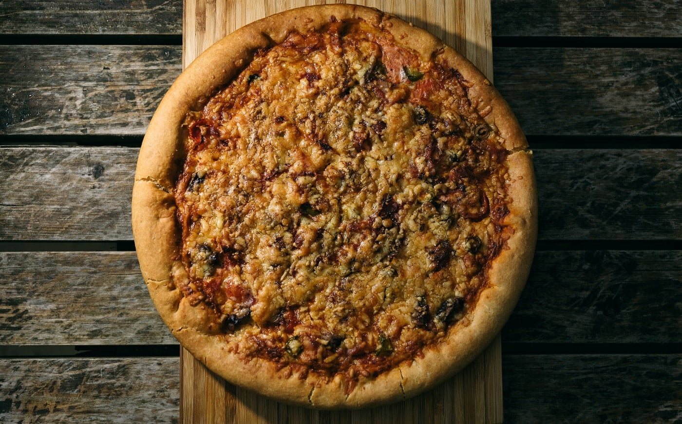 A high angle shot of a freshly baked pizza on a wooden surface