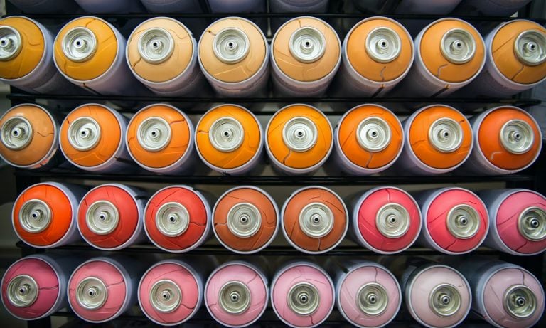 colorful cans of paint stand rows on a shelf