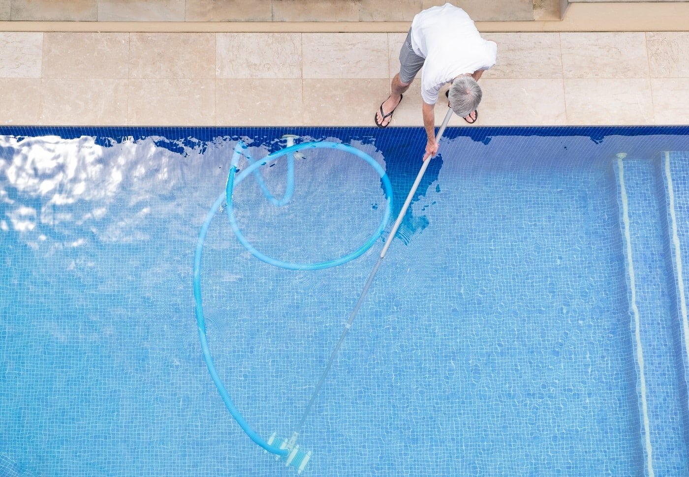 top view of man cleaning a swimming pool. Best Telescopic Pool Pole.