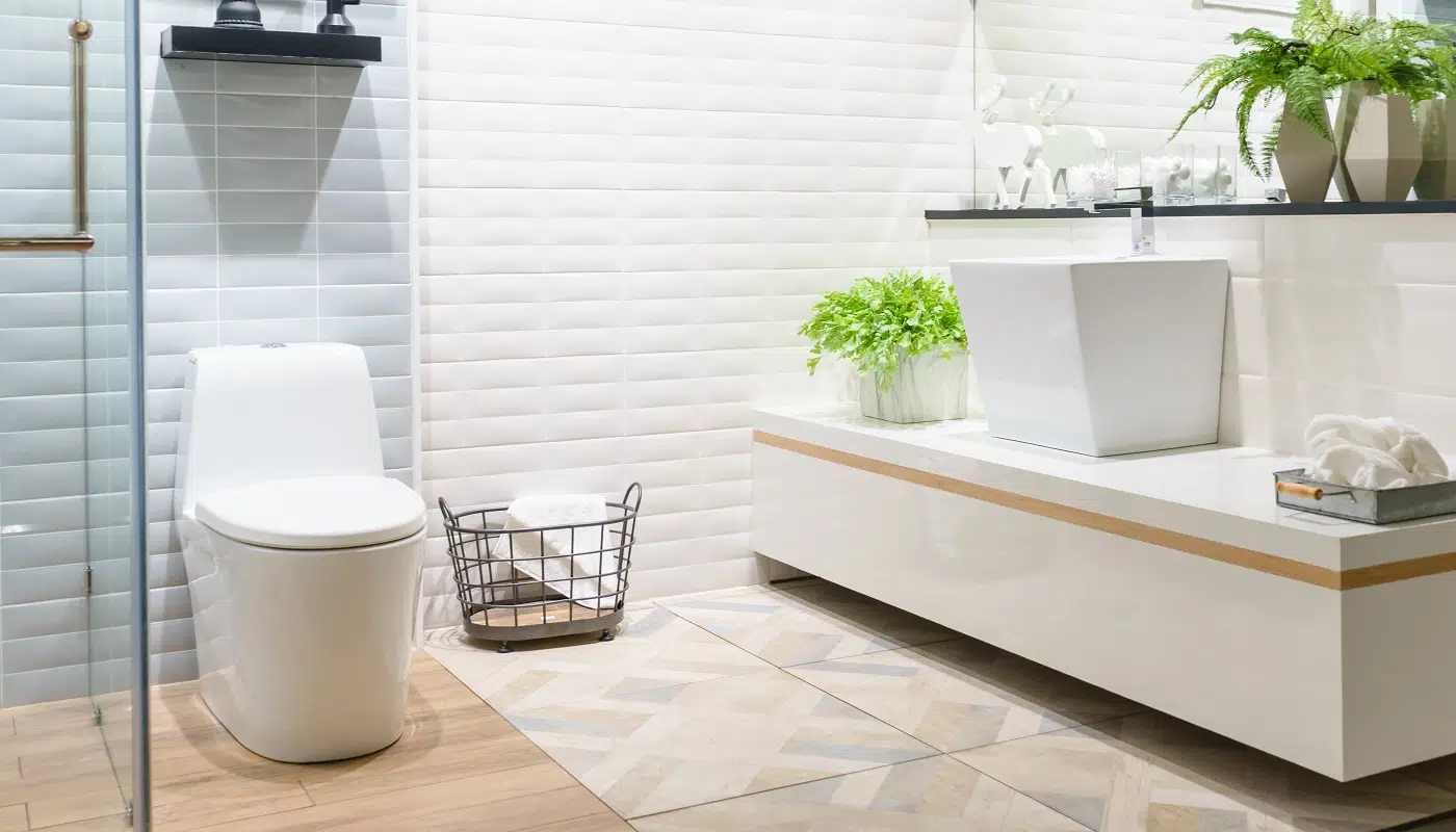 Modern spacious bathroom with bright tiles with toilet and sink. Side view