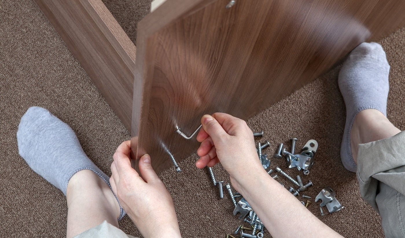 Woodworker assembling furniture at home using hex wrench, allen key. Verdict On Screws For Particle Board