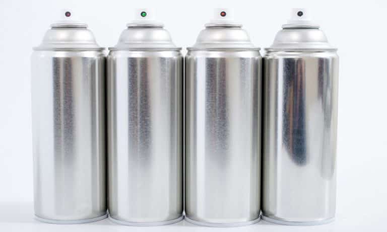 Close up view of silver spray cans on a white background.