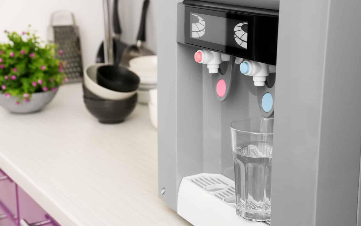 Modern water cooler with glass on kitchen table