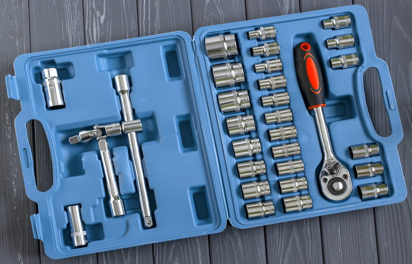 A set of socket wrenches in a convenient case. Top view. Wooden gray background.