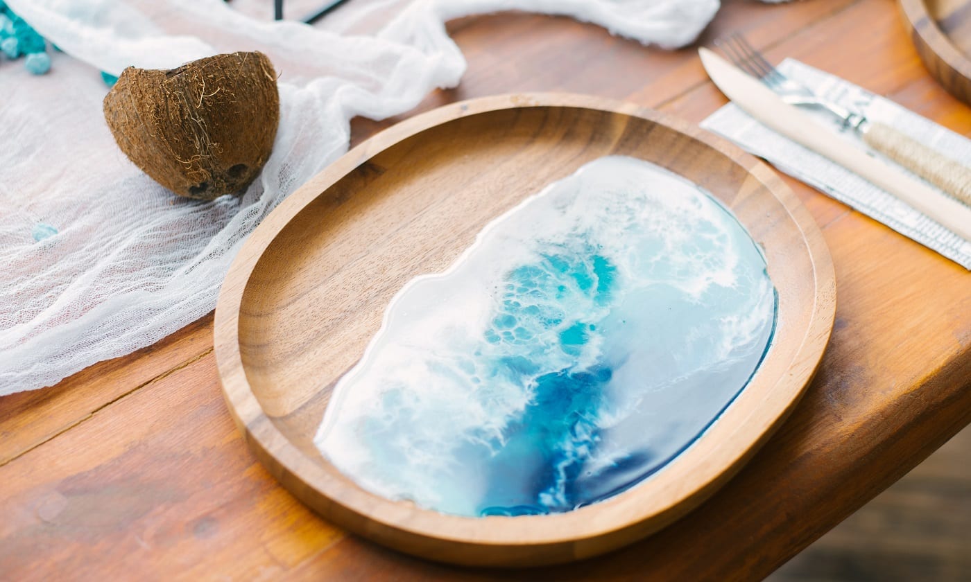 Stylish wooden plate with epoxy resin in the form of the sea or ocean. The trend in the dishes and decor for the home