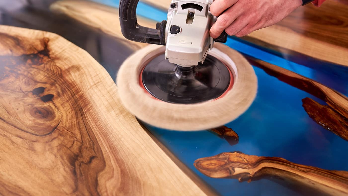 man polishing epoxy table close up.