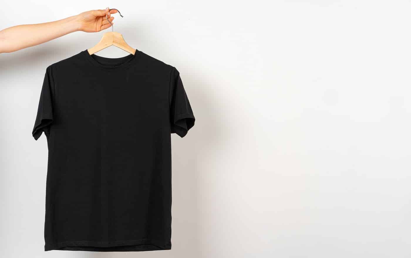 Black plain t-shirt hanging on a hanger, copy space