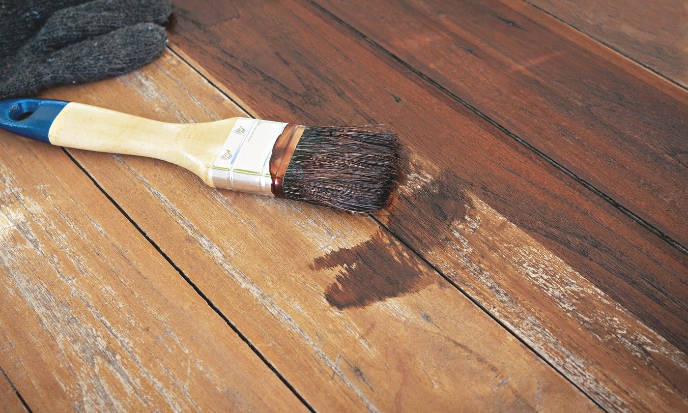 paintbrush and gloves put on wood table.