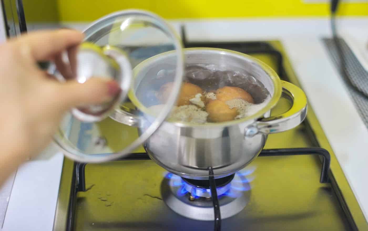 Saucepan with boiling eggs on a gas stove.
