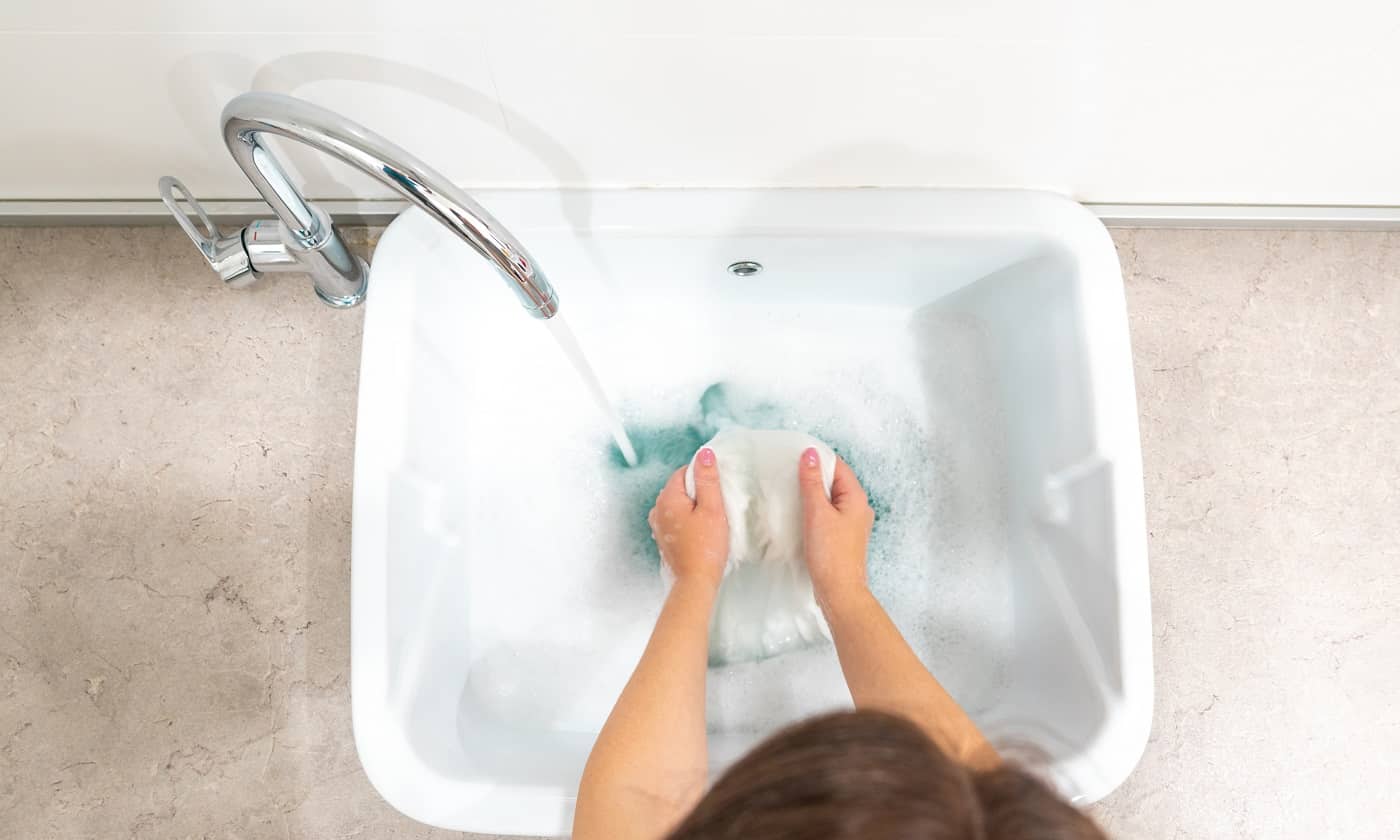 Female hands washing color clothes in basin