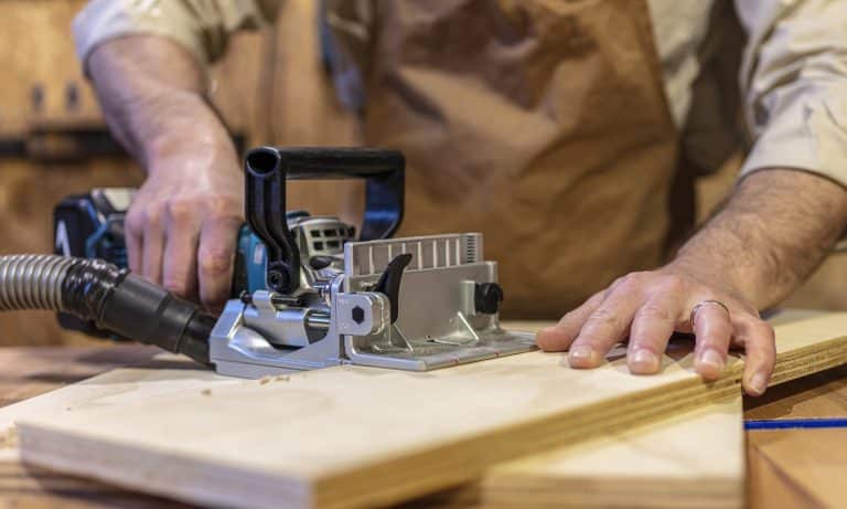 detail of biscuit jointer at work on a plywood board