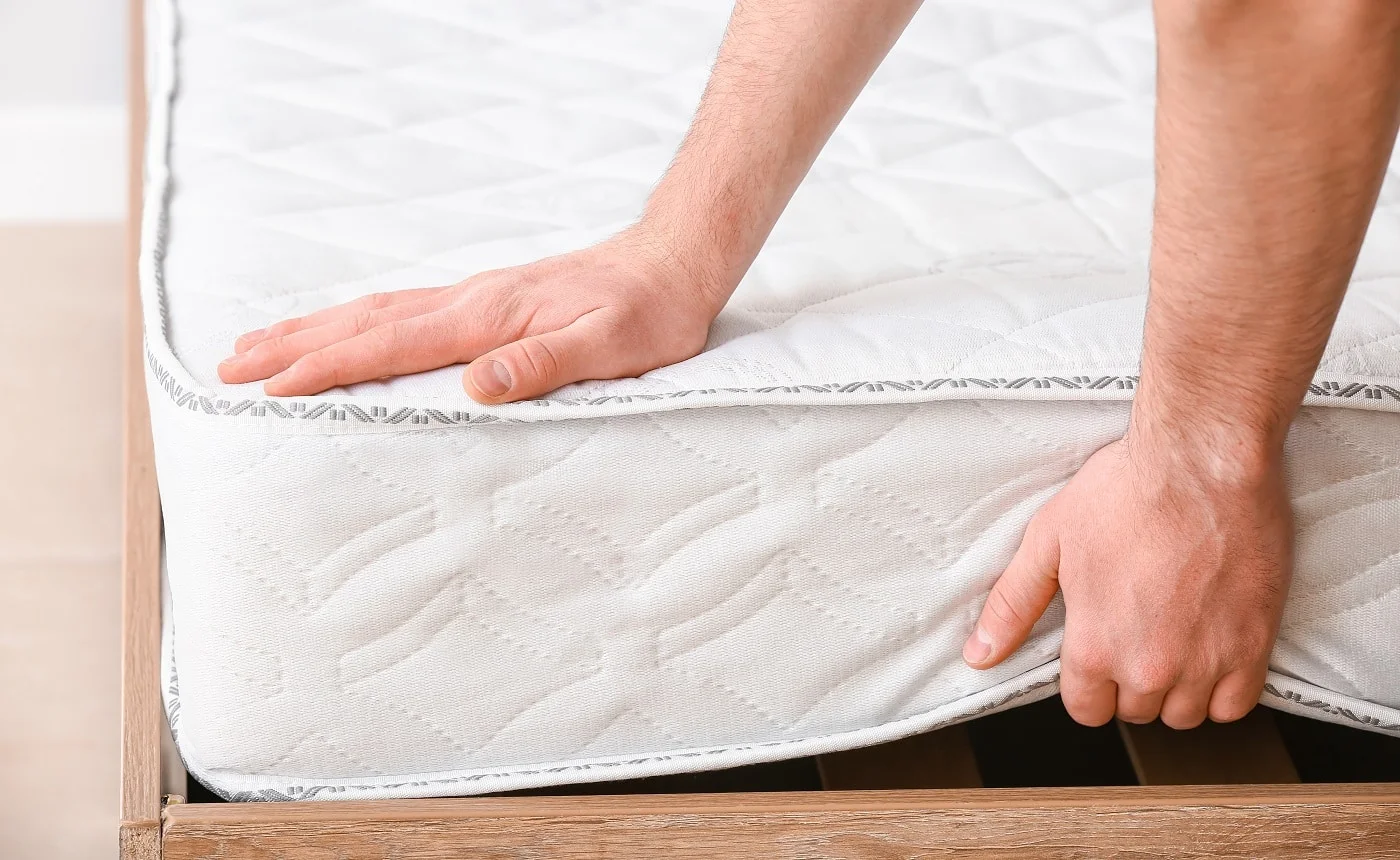 Man choosing orthopedic mattress in store