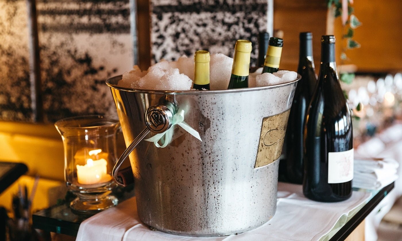 Bottles with champagne are cooling in pail with ice and bottles with wine Types of Buckets