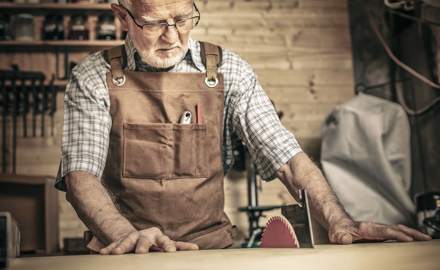 professional carpenter works with a saw bench in his workshop