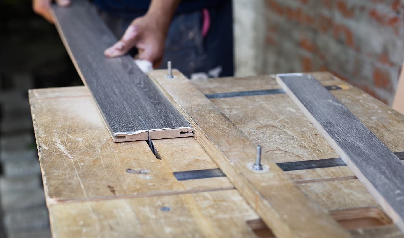 Manufacturing and installation of doors. A carpenter cuts a wooden plank on a lathe.