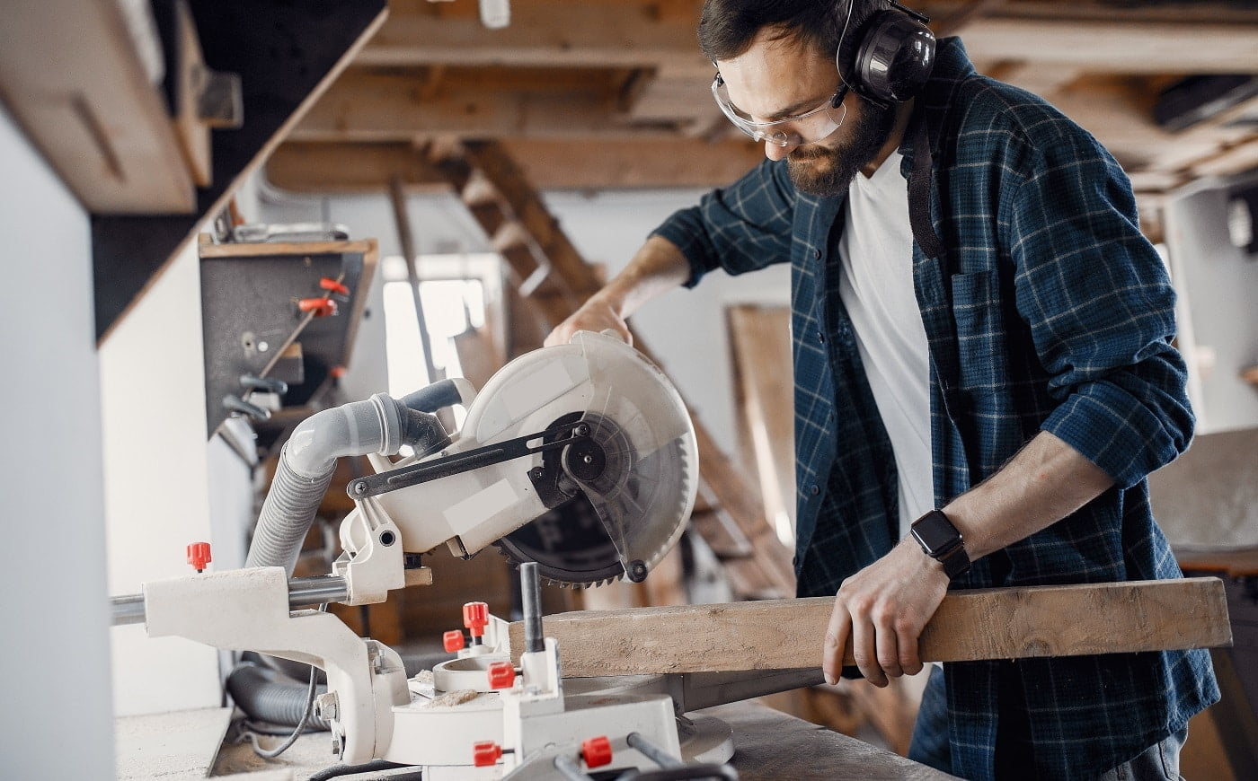 Wood cutting with circular saw. Closeup of mature man sawing lumber.