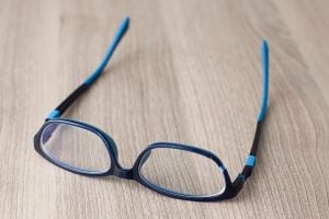 Broken Eyeglasses. Broken glasses on a wooden table. broken eyeglass frames.