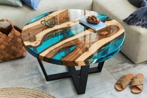 Stylish composition with design epoxy coffee table, sofa, blanket, pillows, book, decoration and personal accessories in modern home décor. Template. Details. Heat Resistant Epoxy