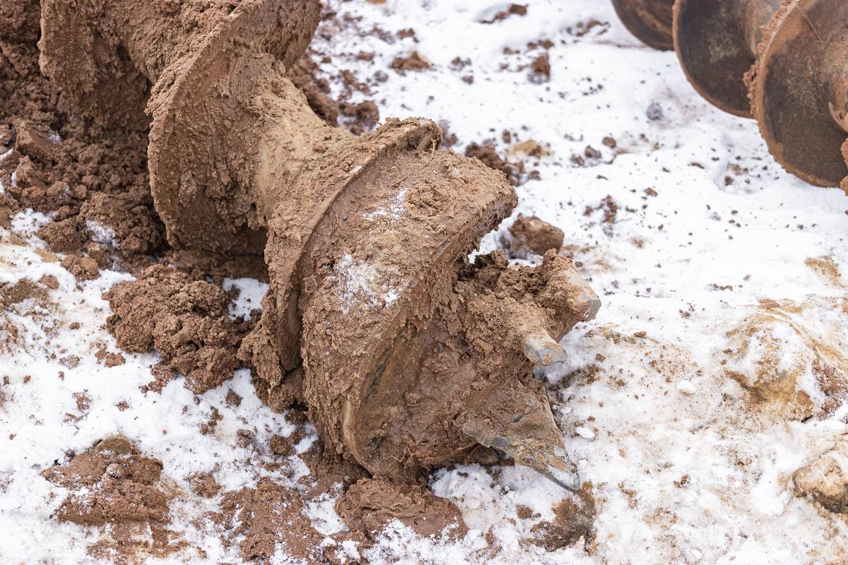 Auger for drilling a well at a construction site. Well drilling in winter