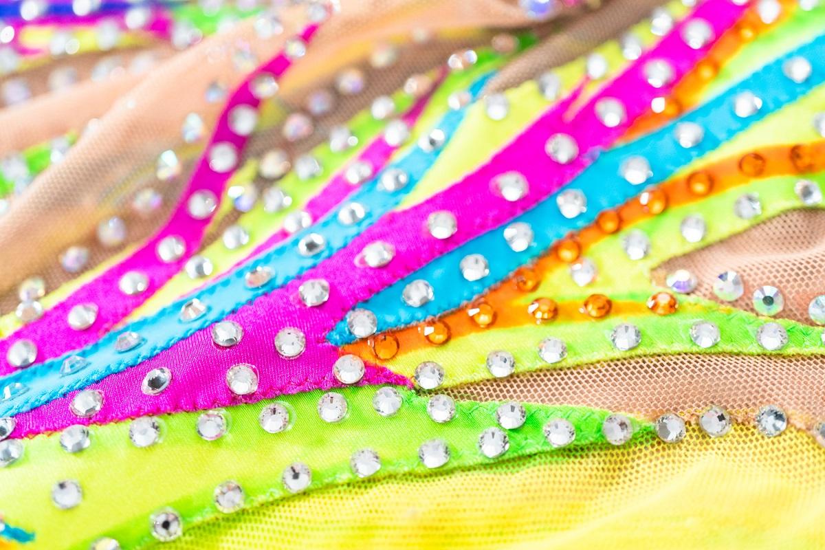 Close up of rhinestones and colorful fabric on figure skating dress created with the best glue for rhinestones