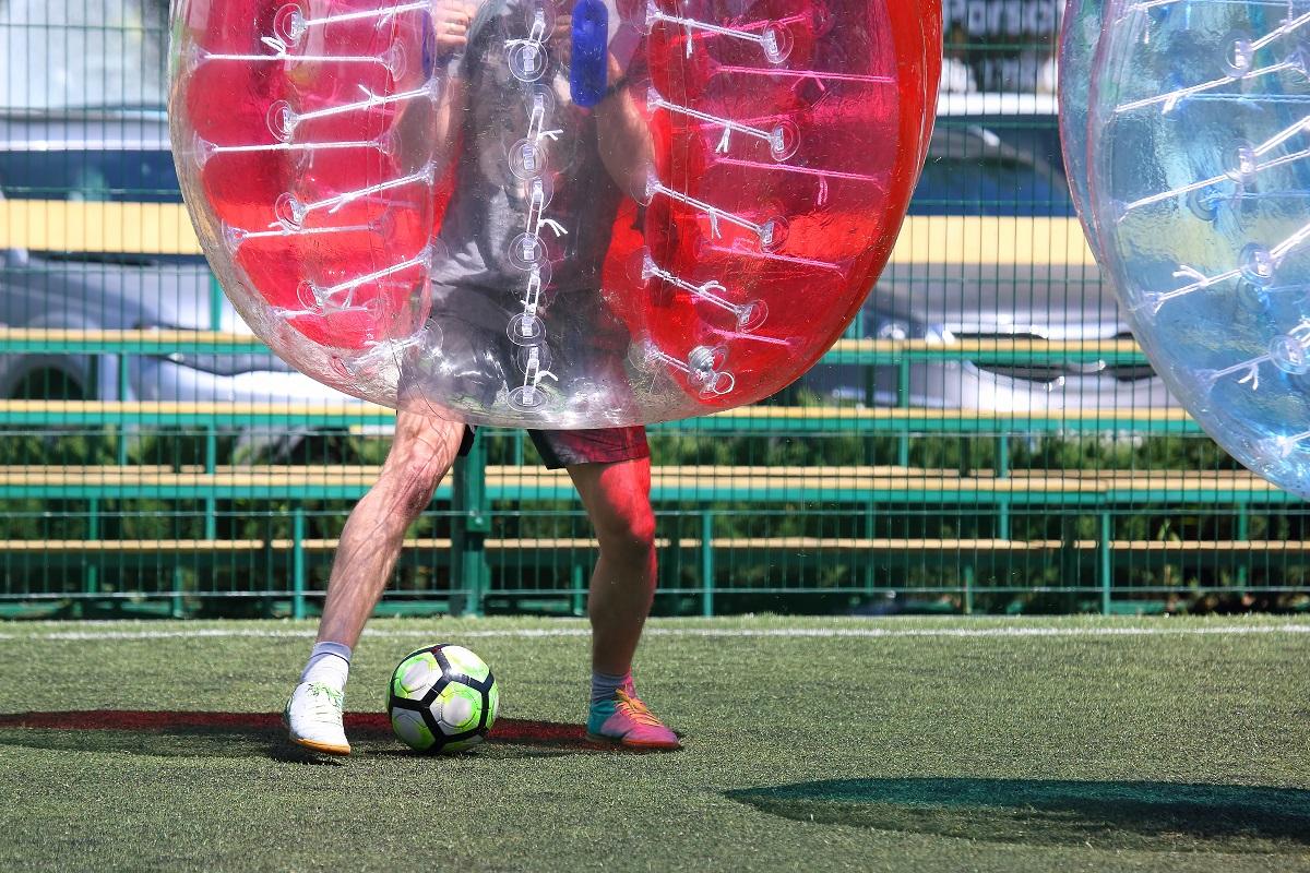 man on a sports field playing in the bumper ball