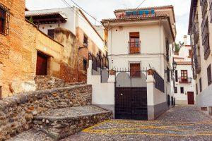 Asymmetrical Design. Scenic alley with traditional Spanish white houses in the old town area of Albaicin, Granada, Andalusia, Spain